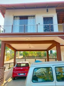a car parked in front of a house with a balcony at Samith Home Stay in Madikeri