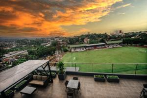- un balcon offrant une vue sur un court de tennis dans l'établissement Rogers Hotel Manado, à Pineleng