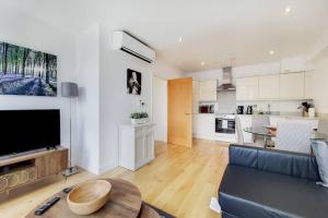 a living room with a blue couch and a kitchen at BR6 - Beautiful 1 bed flat in heart of borough in London