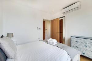 a white bedroom with a bed with towels on it at BR6 - Beautiful 1 bed flat in heart of borough in London