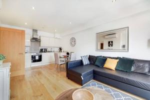 a living room with a blue couch and a kitchen at BR6 - Beautiful 1 bed flat in heart of borough in London