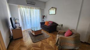 uma sala de estar com um sofá e uma televisão em Super luminoso y cómodo depto en Belgrano 3 habit. em Buenos Aires