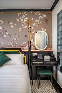 a bedroom with a bed and a desk with a mirror at White Lotus Boutique Hotel, Ho Chi Minh in Ho Chi Minh City