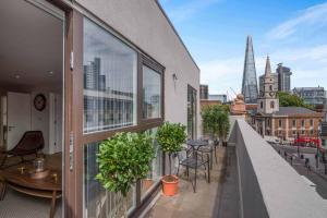 a balcony with tables and chairs and a view of a city at Number 7 Borough Apartments 2 Bed 2 Bath in London