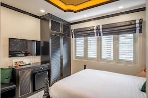 a bedroom with a bed and a desk and a window at White Lotus Boutique Hotel, Ho Chi Minh in Ho Chi Minh City