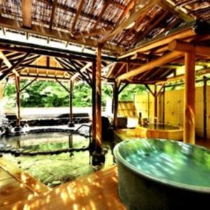 a large room with a large tub in a building at Hotel Okuyumoto in Hakone