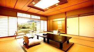 a living room with a table and chairs and a window at Hotel Okuyumoto in Hakone