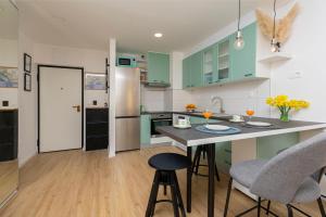 a kitchen with green cabinets and a island with bar stools at Apartment Cute in Omiš