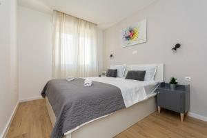 a bedroom with a large bed in a white room at Apartment Cute in Omiš