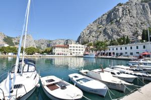 a group of boats docked in a harbor with a mountain at Apartment Cute in Omiš