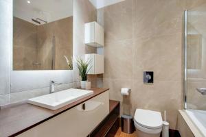 a bathroom with a sink and a toilet and a mirror at Number 8 Borough Apartments 2 Bed 2 Bath in London