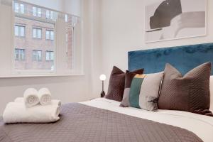 a bedroom with a large bed with pillows and a window at Number 8 Borough Apartments 2 Bed 2 Bath in London