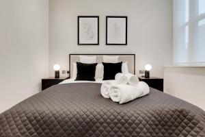 a bedroom with a large bed with towels on it at Number 10 Borough Apartments 2 Bed 2 Bath in London