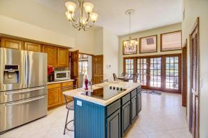 a large kitchen with a refrigerator and a counter top at Florida Vacation Rental with Private Pool and Dock! in Merritt Island
