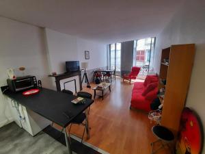 salon z czerwoną kanapą i stołem w obiekcie Charmant T2 au cœur de Bayonne, proche commodités - FR-1-239-891 w Bajonnie +4 zdjęcia