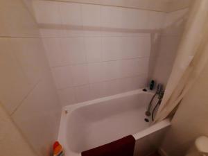 - białą wannę w wyłożonej białymi kafelkami łazience w obiekcie Charmant T2 au cœur de Bayonne, proche commodités - FR-1-239-891 w Bajonnie