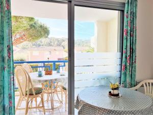 taras ze stołem i krzesłami na balkonie w obiekcie Appartement familial avec piscine, terrasse et parking au Lavandou - 5 couchages - FR-1-251-487 w mieście Le Lavandou