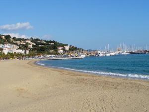 piaszczysta plaża z łodziami w wodzie w obiekcie Appartement familial avec piscine, terrasse et parking au Lavandou - 5 couchages - FR-1-251-487 w mieście Le Lavandou