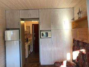 een keuken met witte kasten en een koelkast bij Studio Villard-de-Lans, 1 pièce, 4 personnes - FR-1-515-154 in Villard-de-Lans