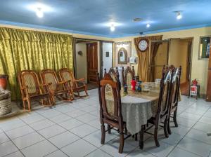 a dining room with a table and chairs and a clock at Hotel Fuente de Paz Managua in Managua