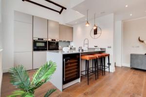 a kitchen with white cabinets and a island with bar stools at Number 12 Borough Apartments 2 Bed 2 Bath in London