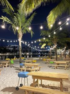 a beach with picnic tables and palm trees at night at VINHOME OCEAN PARK GIA LÂM in Hanoi