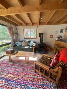 sala de estar con sofá y mesa en Alpacas Off Grid - Eco Cabin en Takaka