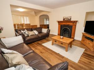 a living room with a couch and a fireplace at 4 Green Farm Cottage in Chester