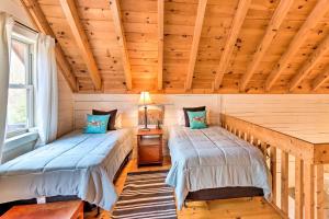 2 Betten in einem Zimmer mit Holzdecken in der Unterkunft Awesome Murphy Cabin with Dock on Nottely River in Murphy