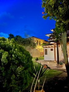 vista su un cortile con una casa di notte di Voyaca Hotel Alfareria a Villa de Leyva