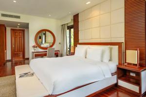 1 dormitorio con 1 cama blanca grande y espejo en Resort Villa Da Nang Luxurious, en Da Nang