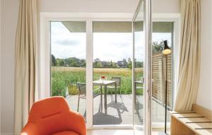 un salon avec une chaise orange et un balcon dans l'établissement Fewo 24 Putbus-rgen, à Wreechen