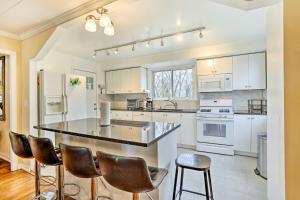 una cocina con armarios blancos y taburetes de bar en Family Vacation Rental 18 Mi to Philadelphia, en Gibbstown