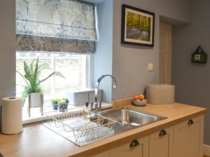 a kitchen counter with a sink and a window at Bluebell Cottage in Alnwick