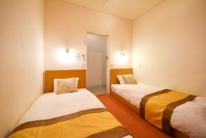 a room with two beds in a room at Comfy Stay Sarusawaike in Nara