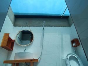 a bathroom with a mirror and a sink and a toilet at Hong Thu Homestay & Bungalow in Quang Ba