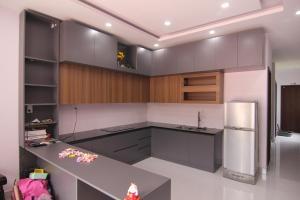 a kitchen with gray cabinets and a stainless steel refrigerator at Dory Homestay in Hue