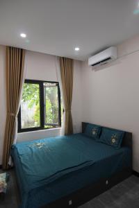 a bedroom with a blue bed and a window at Dory Homestay in Hue