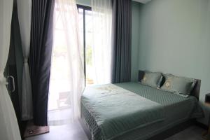 a bedroom with a bed and a large window at Dory Homestay in Hue