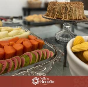 a plate of food with fruit and a cake on a counter at Valle da Benção Pousada in Chapada dos Guimarães