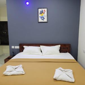 1 dormitorio con 1 cama con 2 toallas en Nilton Bay Residency, en Pondicherry