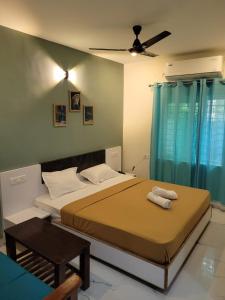 1 dormitorio con 2 camas y ventilador de techo en Nilton Bay Residency, en Pondicherry
