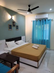a bedroom with a large bed with blue curtains at Nilton Bay Residency in Puducherry