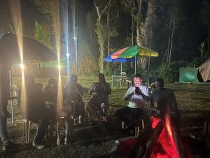 um grupo de pessoas sentadas em um parque à noite em Sri Lakshmi Estates em Siddapur