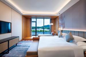 een hotelkamer met een groot bed en een televisie bij Crowne Plaza Huzhou by IHG in Huzhou