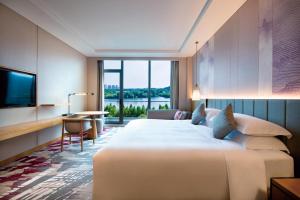 een hotelkamer met een groot bed en een televisie bij Crowne Plaza Huzhou by IHG in Huzhou