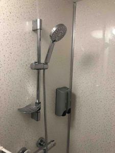 a shower with a shower head in a bathroom at Newly refurbished studio, great location 8 studios in Nottingham
