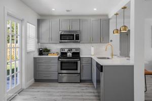 a kitchen with stainless steel appliances and gray cabinets at West Palm Beach Tropical Oasis in West Palm Beach