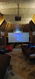 una sala de estar con una pantalla grande en un edificio en Colibamboo The Cabin. Cabaña elevada con mirador montaña malla y jacuzzi, en Pacho