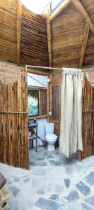 une salle de bain avec toilettes dans une cabane en bois dans l'établissement Colibamboo The Cabin. Cabaña elevada con mirador montaña malla y jacuzzi, à Pacho